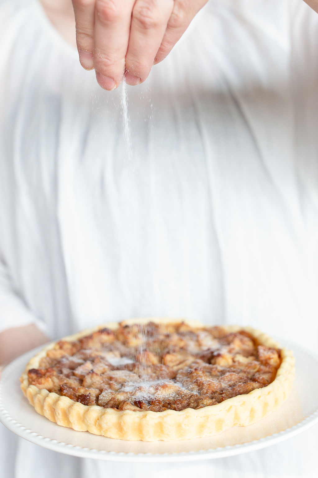 sprinkling sugar on the apple pie