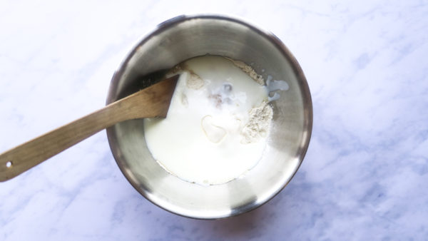 A bowl shows the flour, buttermilk, melted butter and yeast have been added together. 
