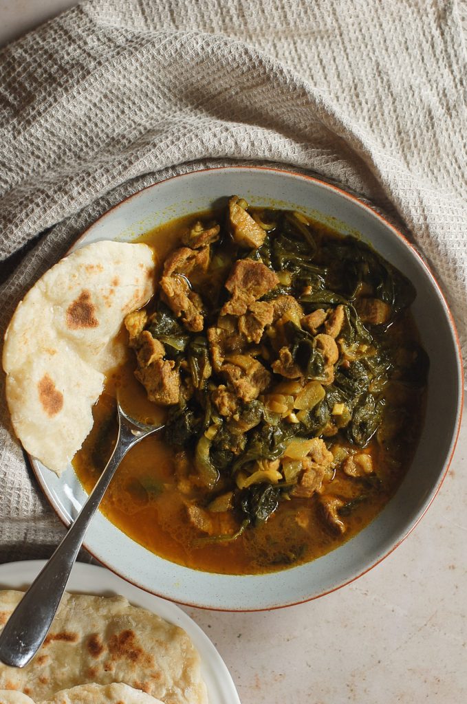 Lamb and spinach curry with a piece of naan bread - Afghan Food