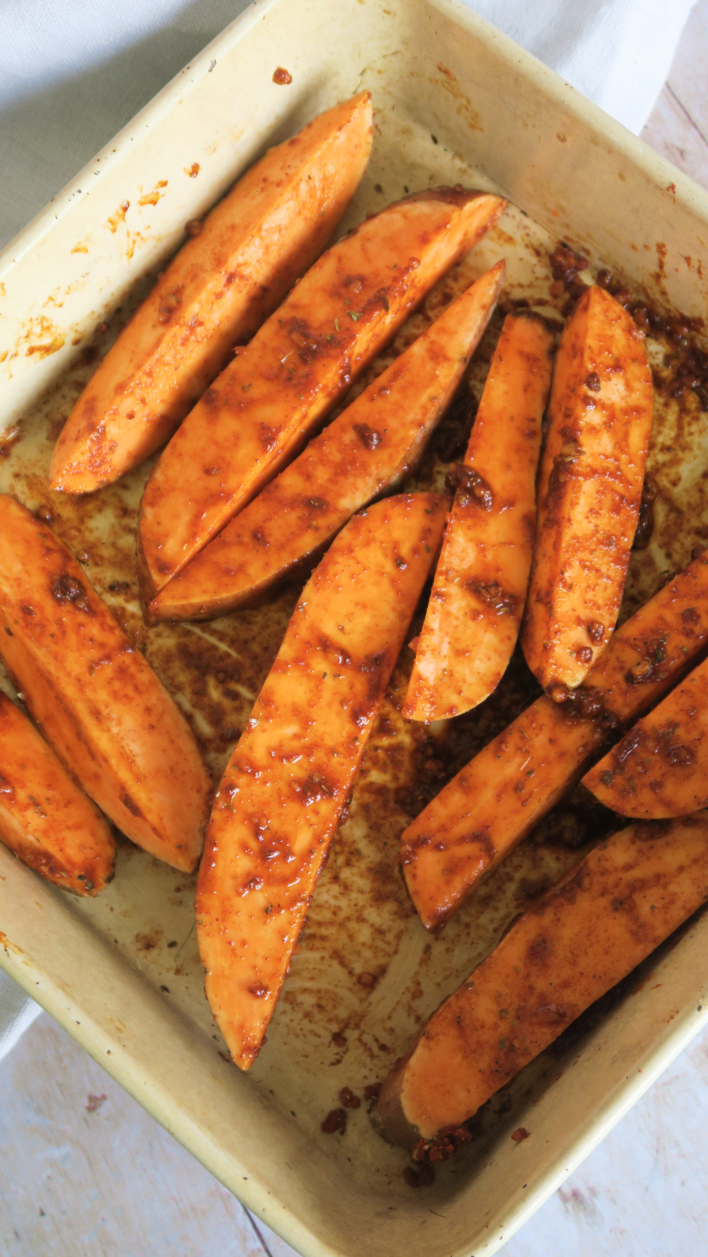 Sweet potato wedges pre-cook in a baking tray 