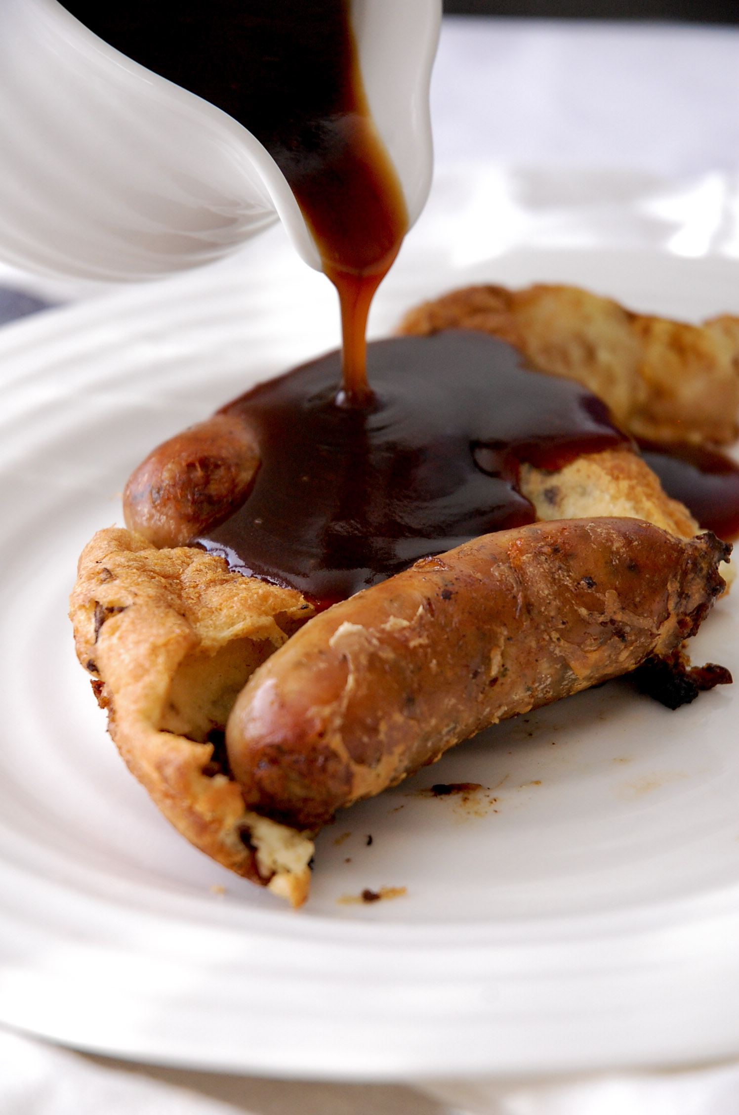 pouring gravy over the toad in the hole