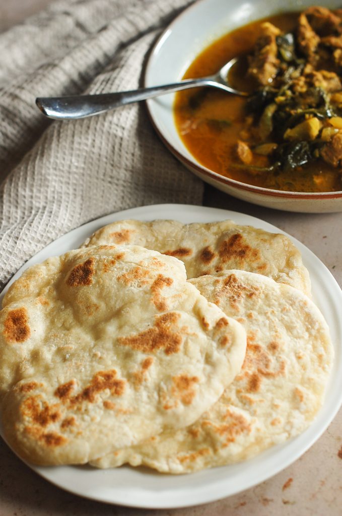 Naan bread with curry in the background