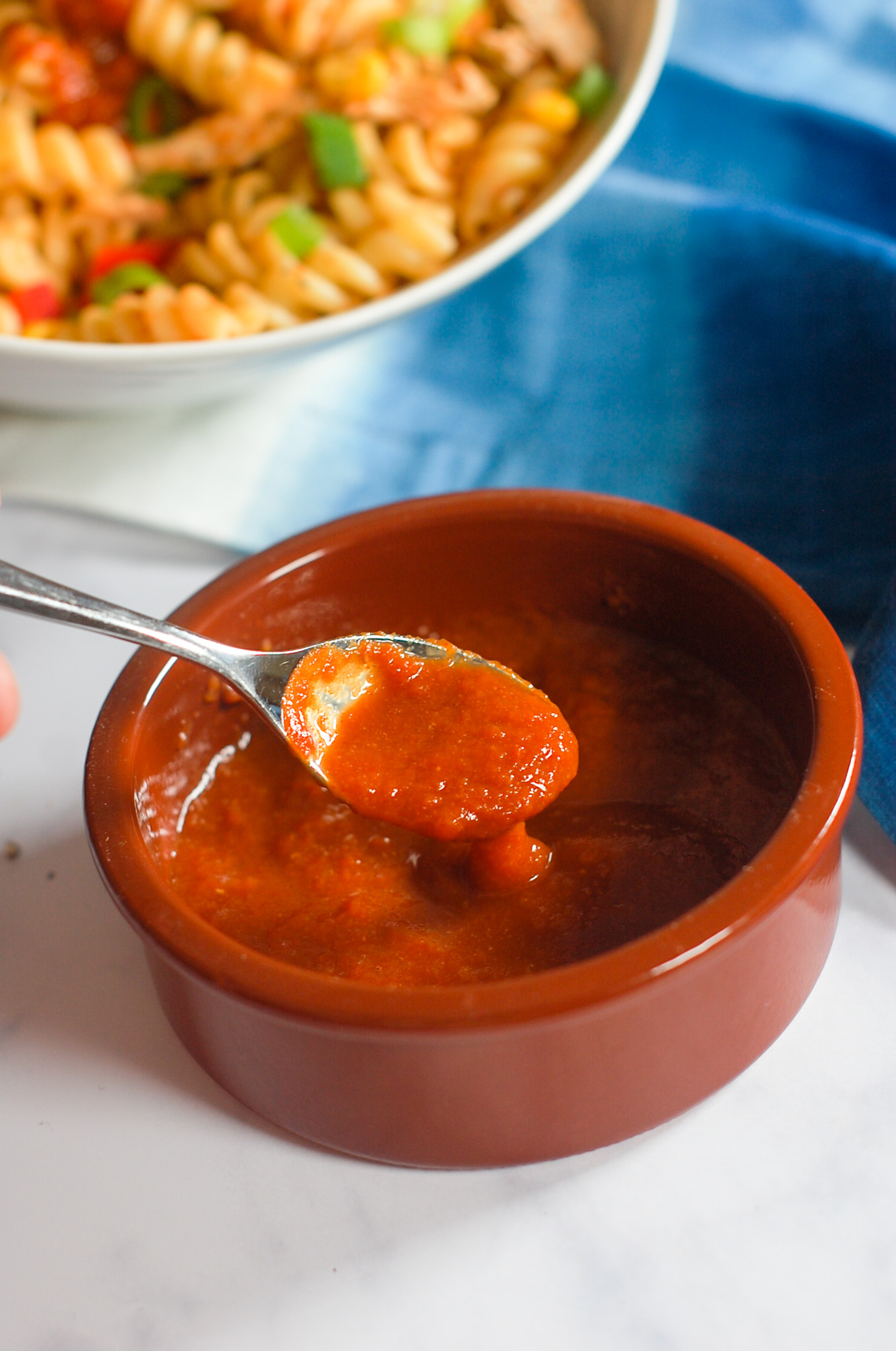 Australian BBQ sauce in a ceramic pot with a spoon