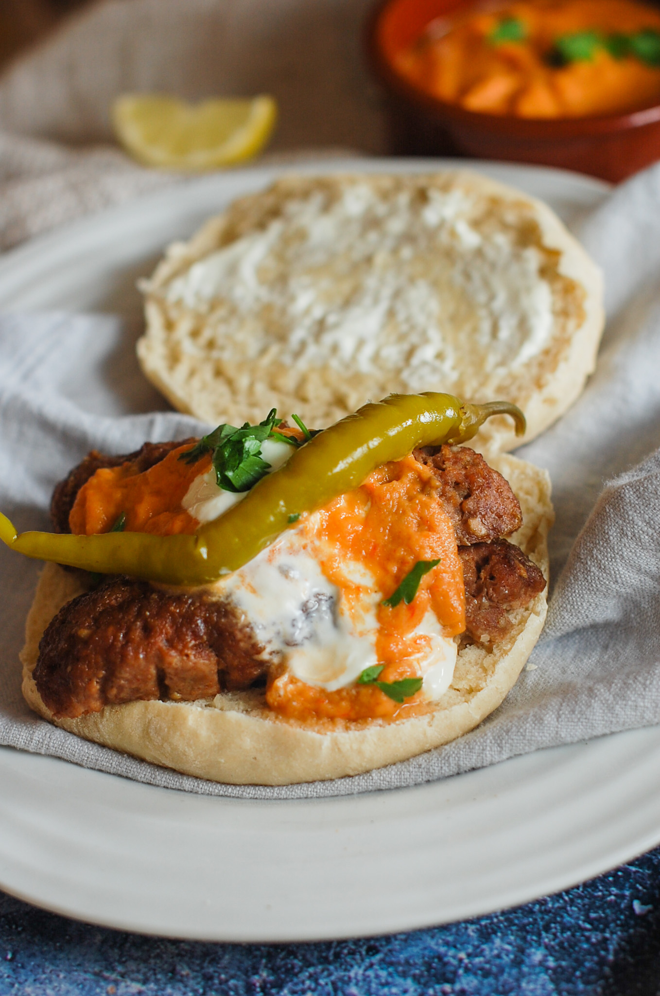 cevapi in lepinja bread with ajvar sauce topping