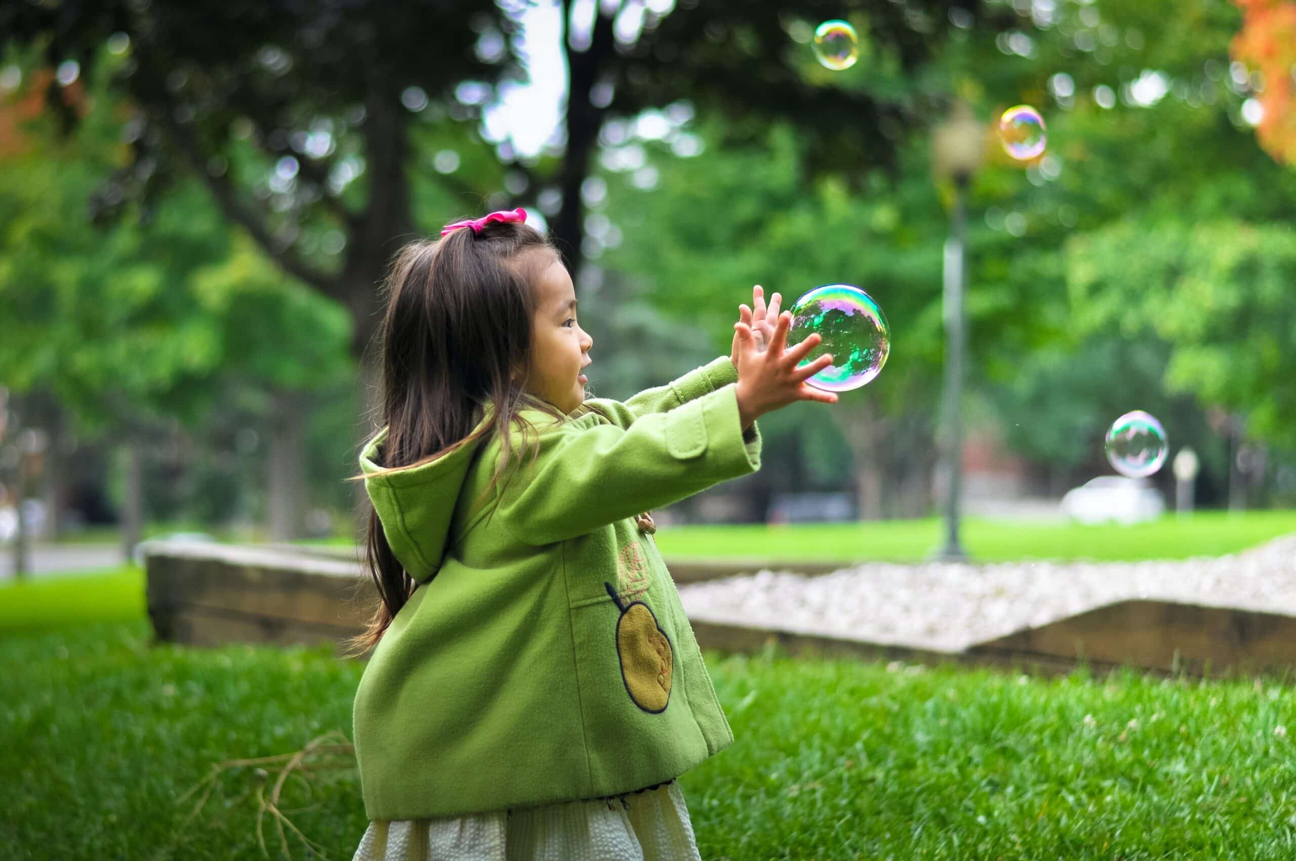 A small girl playing with bubbles