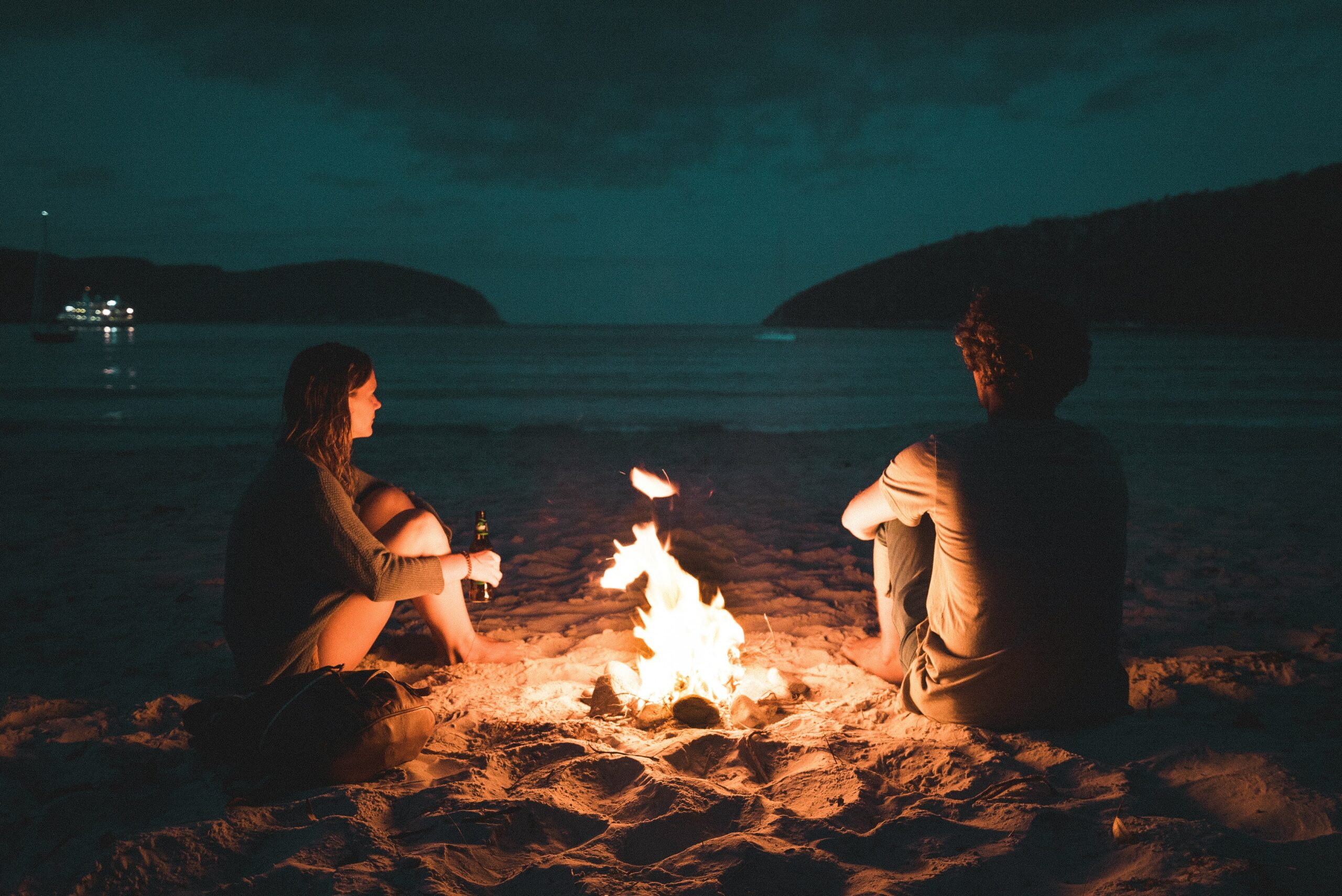 A couple sitting around a campfire