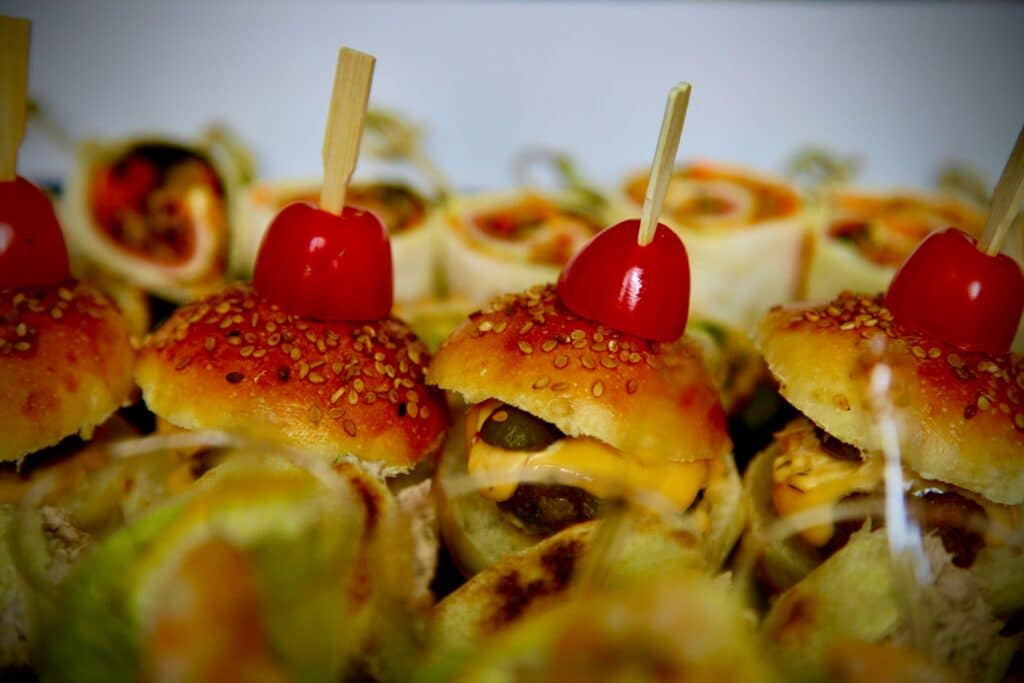 Close up of mini sandwiches with cherries on them. Photo by Zarouri Hicham on Unsplash.