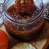 tomato chutney in a jar with some crackers
